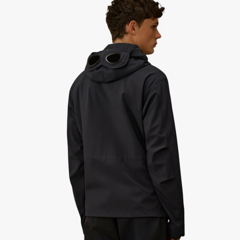 Veste technique noire de la marque CP COMPANY, conçue en collaboration avec RÆW DISTRICT, vue en détail sur l'image.
