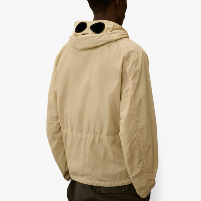 Veste Sahara de CP COMPANY en collaboration avec RÆW DISTRICT, coupe décontractée avec détails en tissu kaki et logo visible.